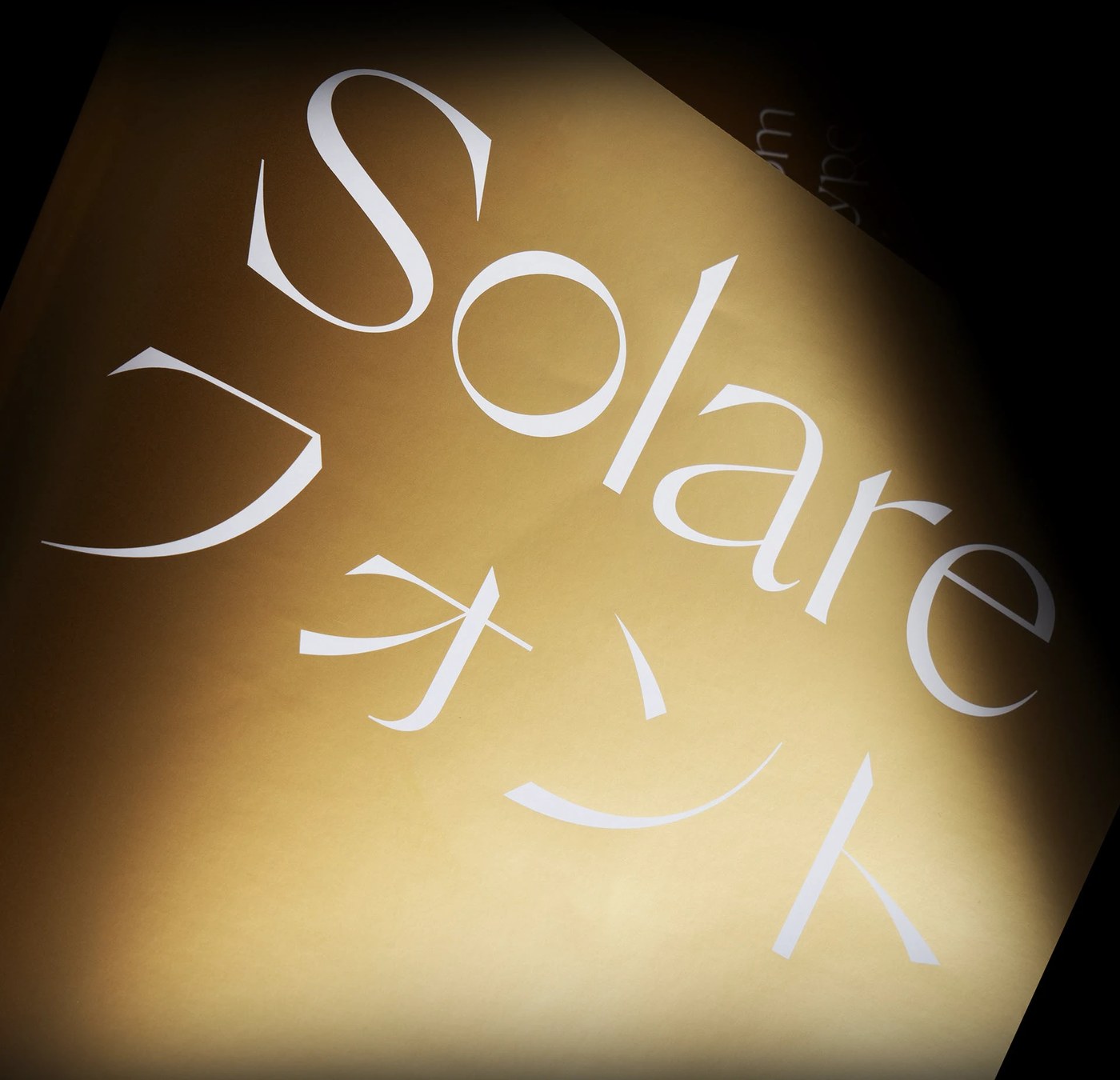 sans serif typeface specimen on gold textured cylinder