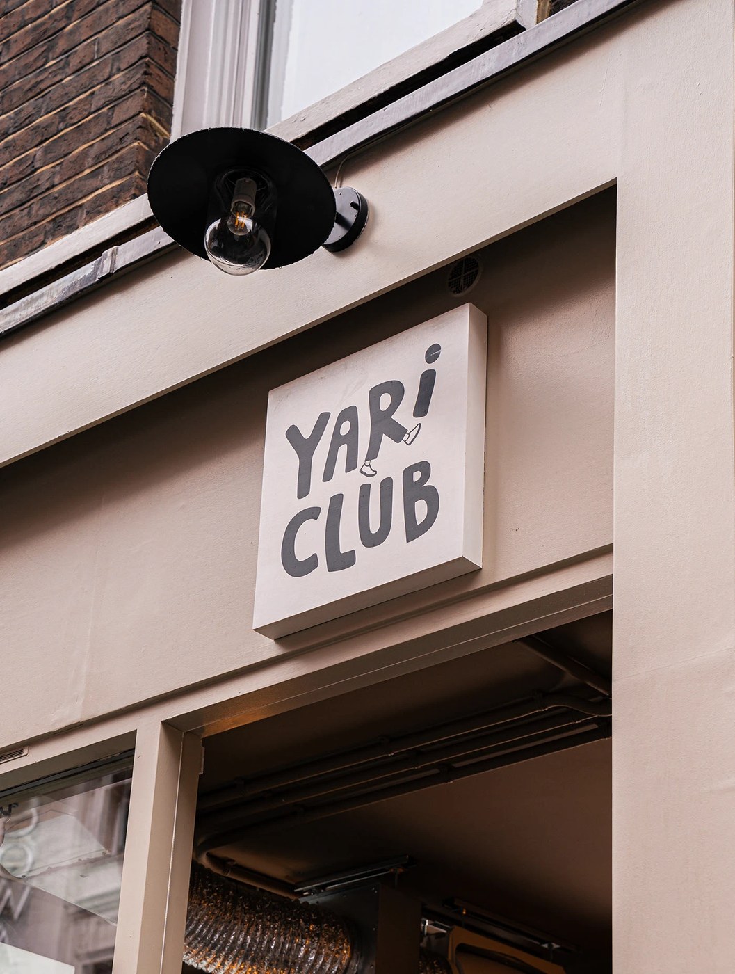 YARI CLUB restaurant brand identity vertical wordmark logo on charcoal packaging box.