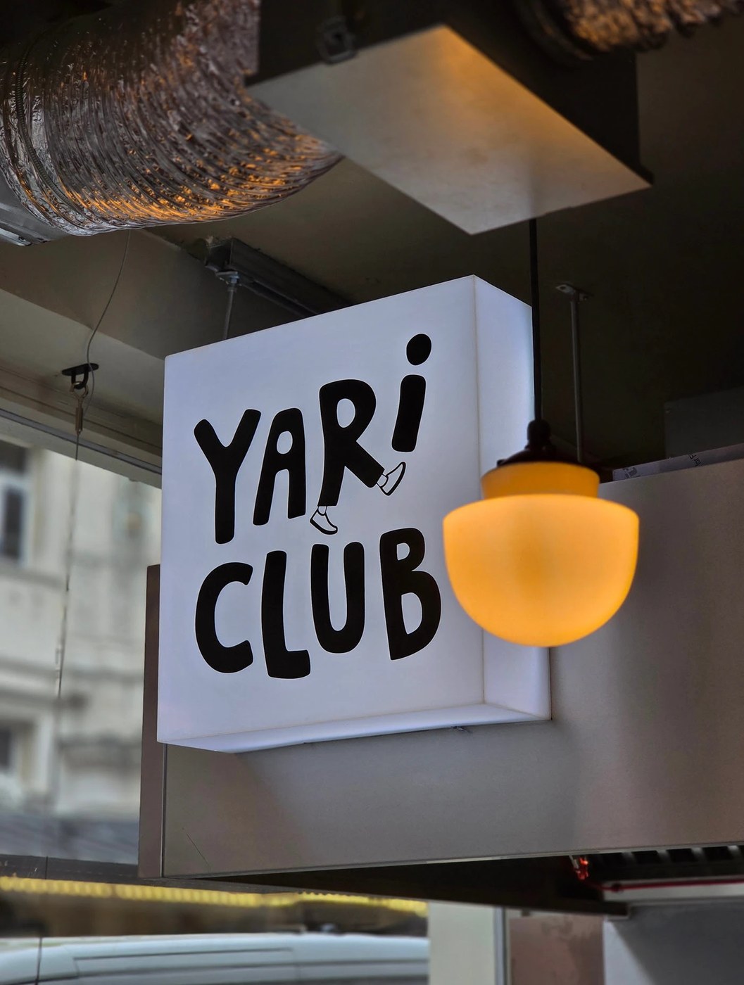 YARI CLUB restaurant brand identity interior shop view featuring concrete structural beams.